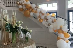 Gold-silver-white-organic-balloon-garland-on-handrail